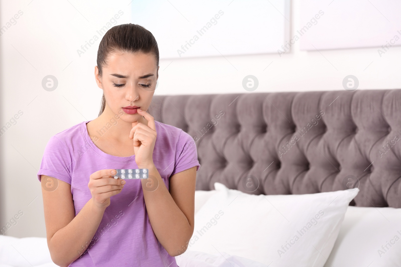 Photo of Beautiful young woman with pills at home