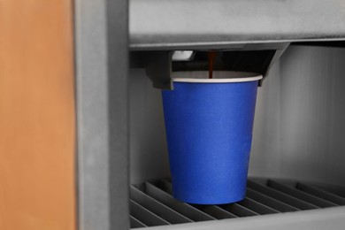 Photo of Vending machine pouring coffee in paper cup, closeup