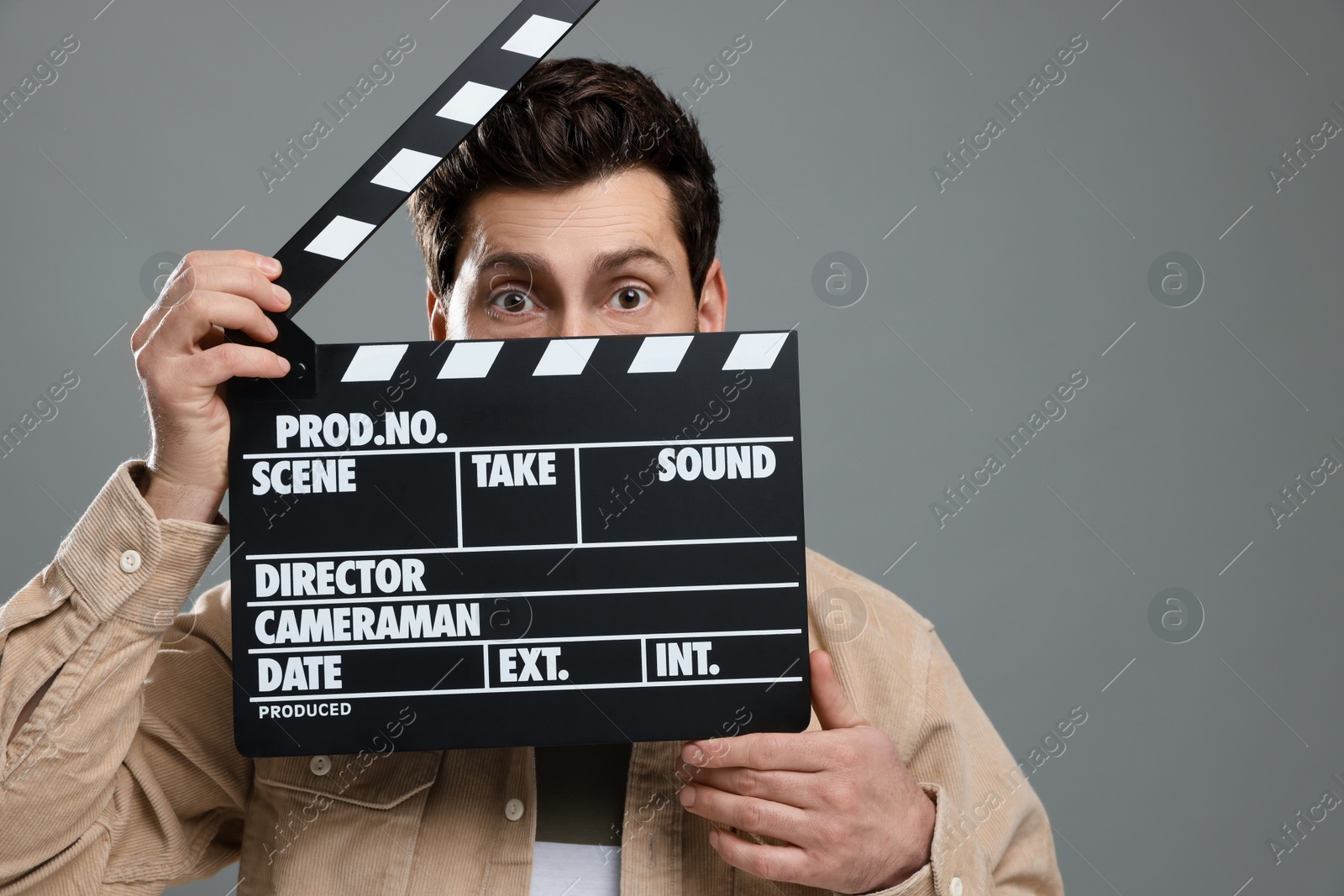 Photo of Actor holding clapperboard on grey background, space for text