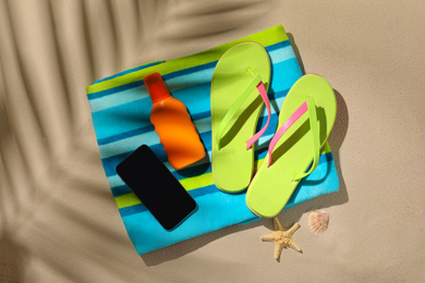 Flat lay composition with  smartphone and beach objects on sand