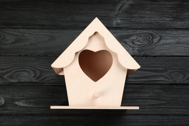 Beautiful bird house on black wooden table, top view