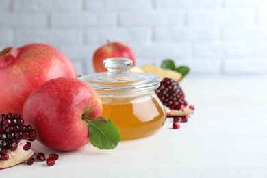 Photo of Honey, pomegranate and apples on white wooden table. Rosh Hashana holiday