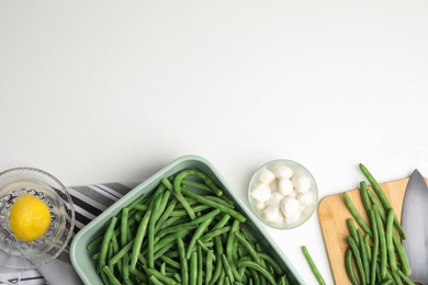 Photo of Flat lay composition with raw green beans on white table. Space for text