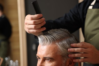 Photo of Hair styling. Professional hairdresser working with client in barbershop, closeup