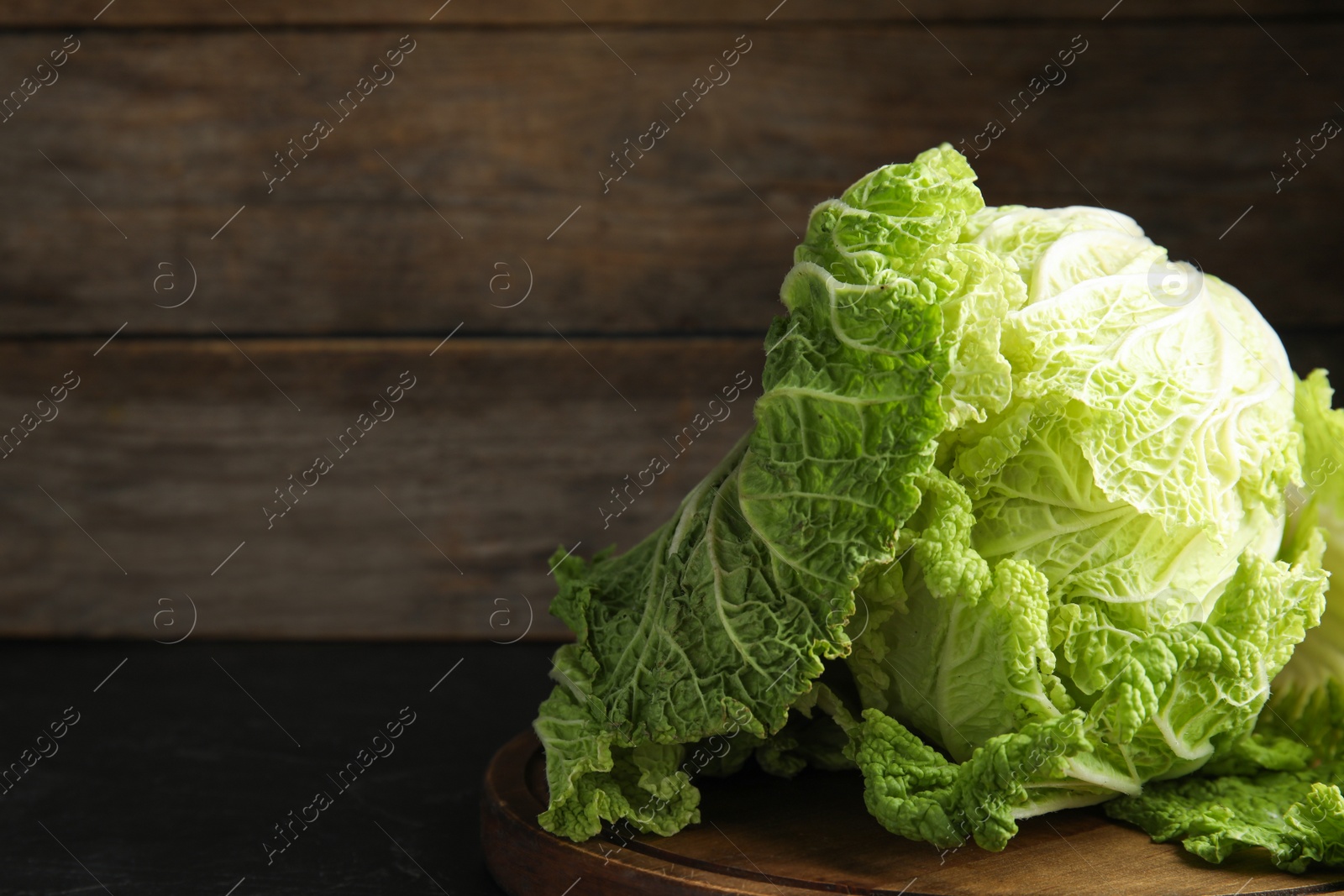 Photo of Fresh ripe Chinese cabbage on black table. Space for text