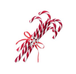 Photo of Sweet Christmas candy canes with red bow and snowflake on white background, top view