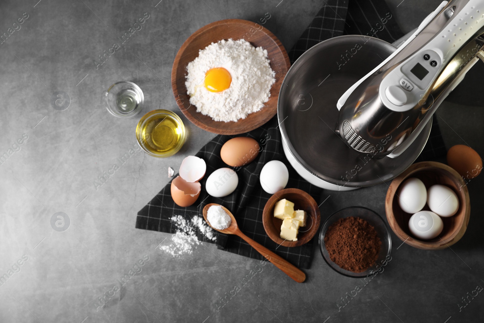 Photo of Stand mixer and different ingredients for dough on grey table, flat lay. Space for text