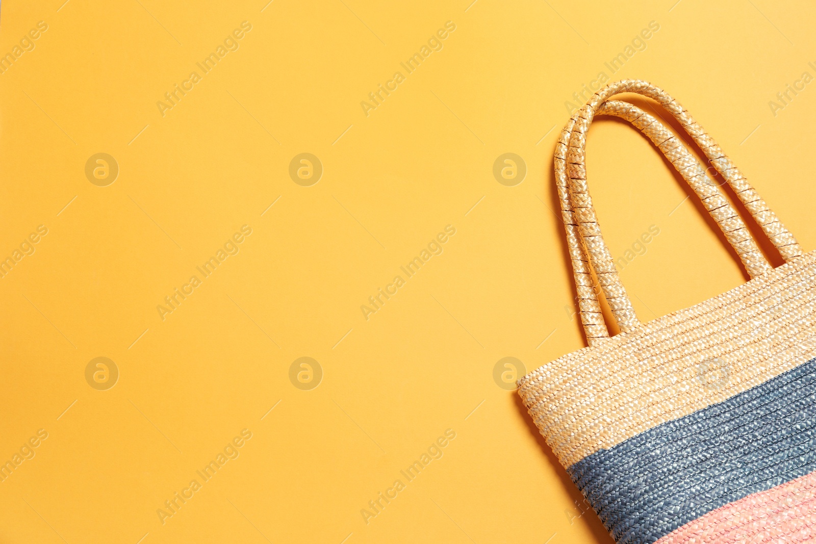 Photo of Stylish bag on color background, top view with space for text. Beach accessories