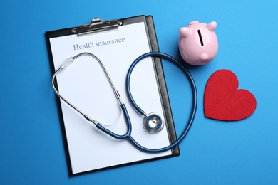 Photo of Flat lay composition with health insurance form and stethoscope on blue background