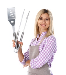 Woman in apron with barbecue utensils on white background