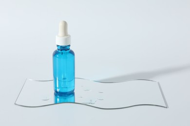 Photo of Bottle with cosmetic product on light background, space for text