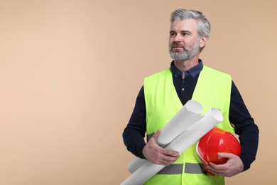 Photo of Architect with hard hat and drafts on beige background. Space for text