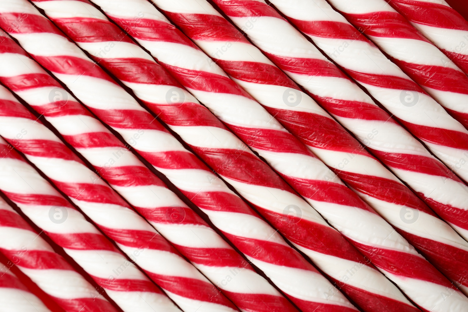 Photo of Sweet candy canes as background, closeup view