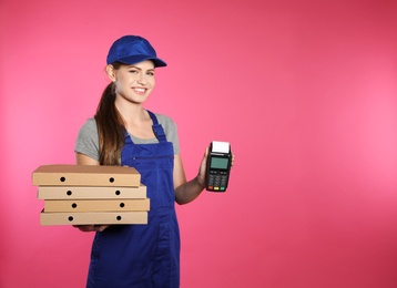 Smiling courier with payment terminal and pizza boxes on color background. Space for text