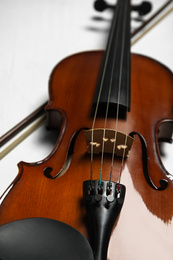 Photo of Beautiful violin and bow on grey table, closeup