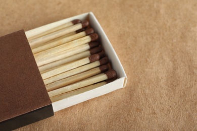 Open box with matches on craft paper, space for text