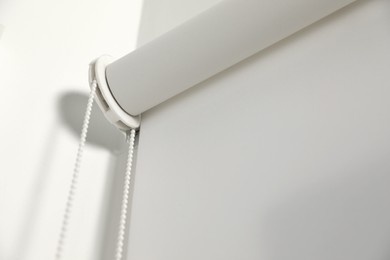 White roller blind in room, closeup view