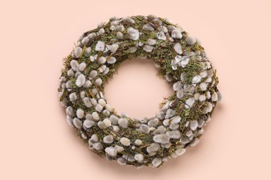 Wreath made of beautiful willow flowers on beige background, top view