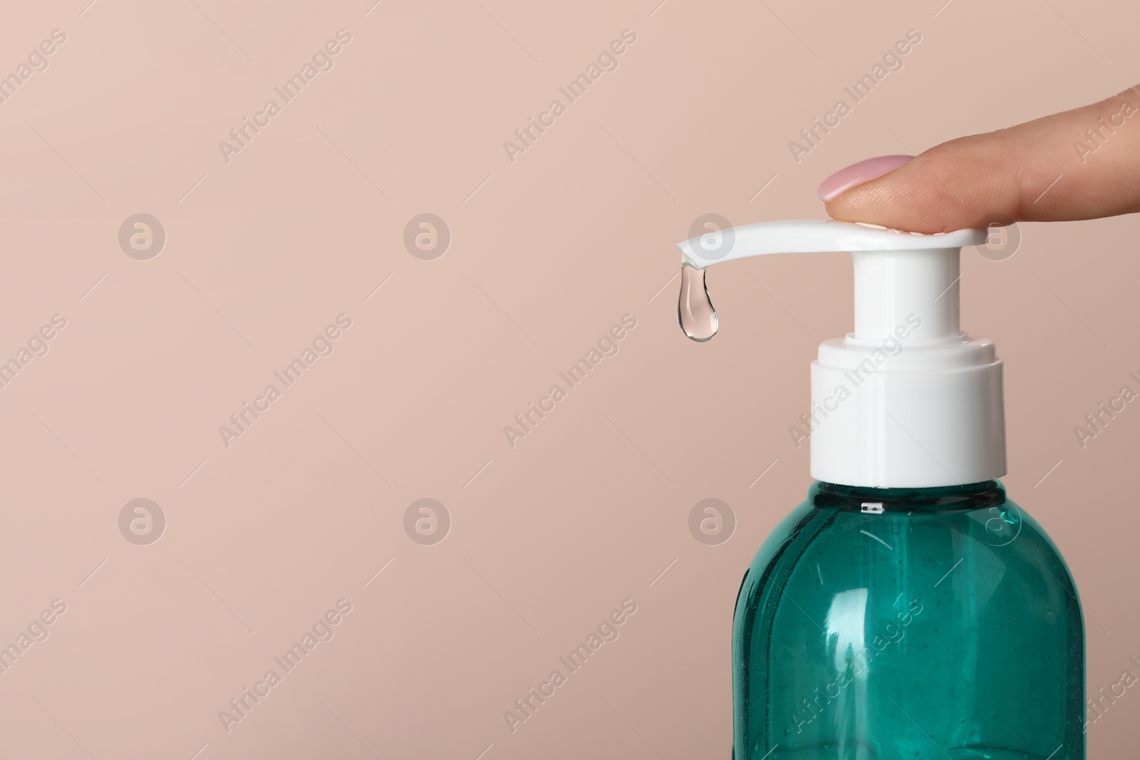 Photo of Woman using cleansing gel on pale pink background, closeup. Space for text