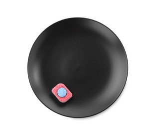 Photo of Black plate with dishwasher detergent tablet on white background, top view