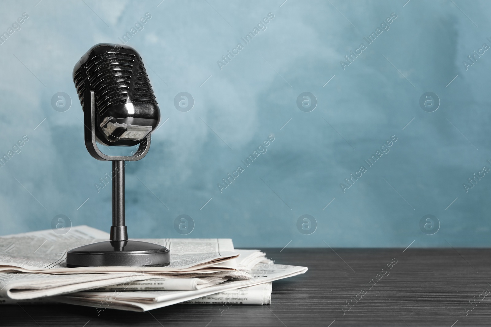 Photo of Newspapers and vintage microphone on table, space for text. Journalist's work