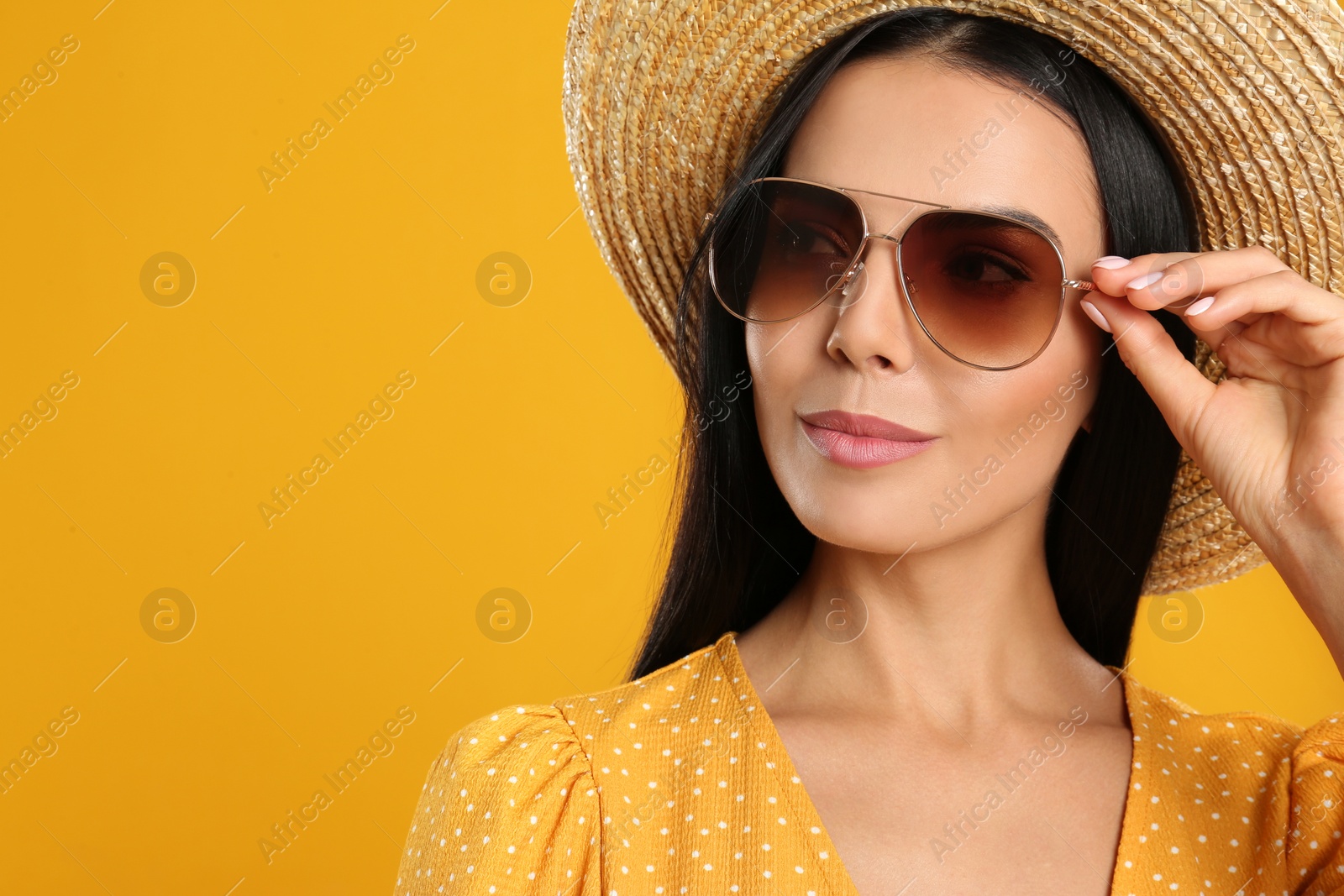 Photo of Beautiful woman wearing sunglasses on yellow background. Space for text