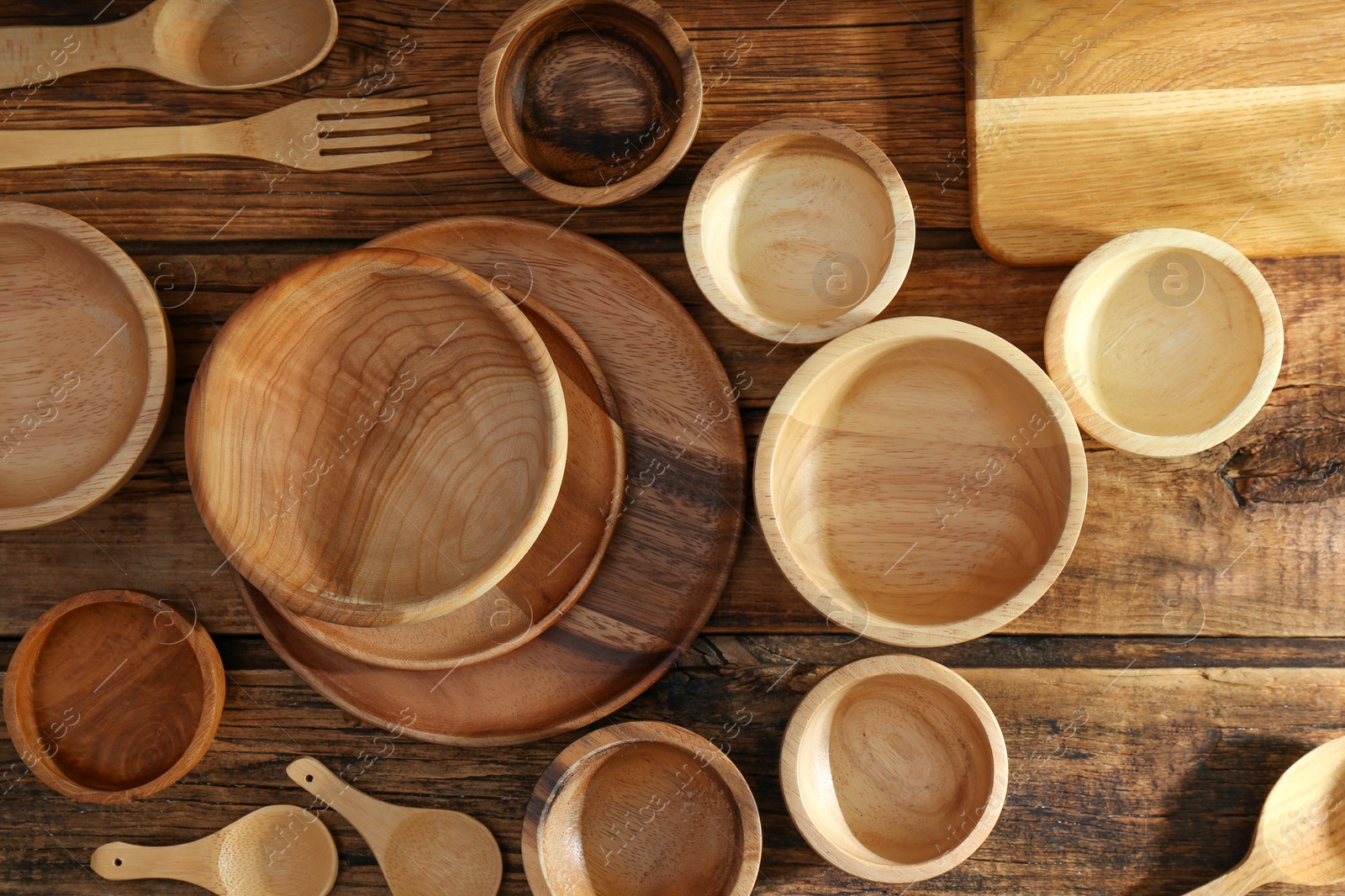 Photo of Many different wooden dishware and utensils on table, flat lay