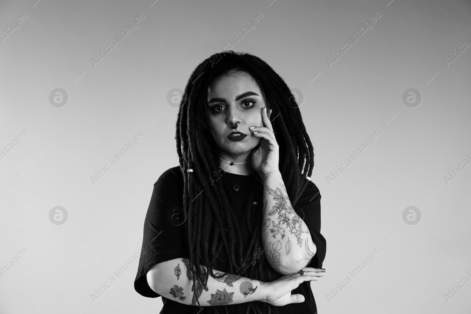 Image of Beautiful young woman with tattoos on light background. Black and white photography