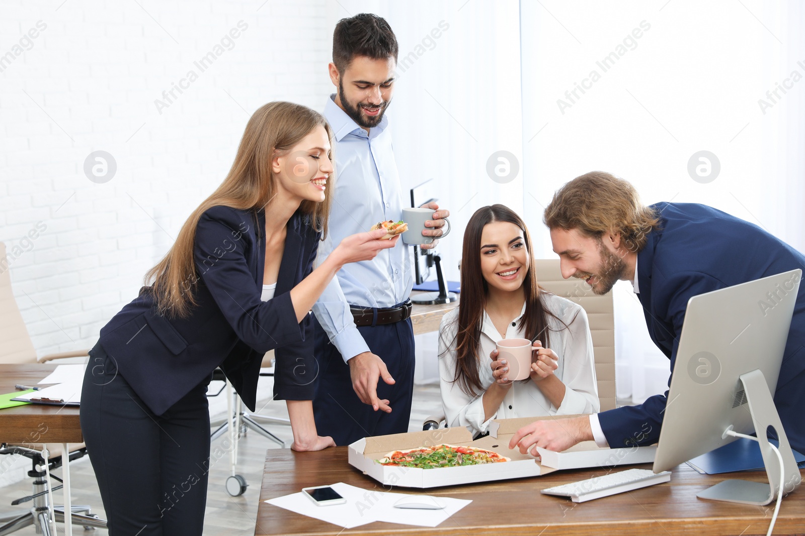 Photo of Office employees having pizza for lunch at workplace. Food delivery