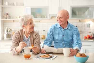 Elderly couple having breakfast in kitchen