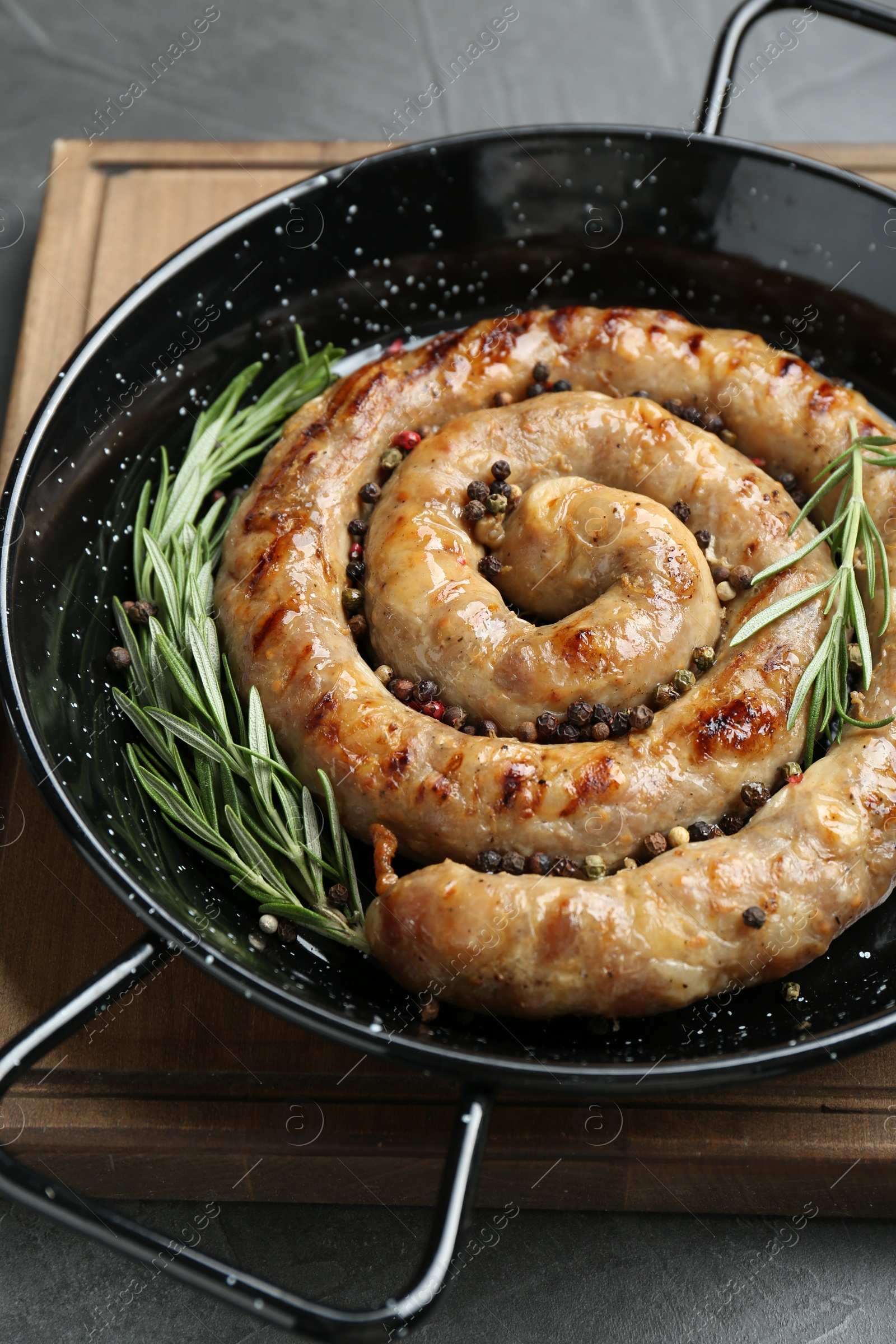 Photo of Tasty homemade sausages with spices on grey table, closeup