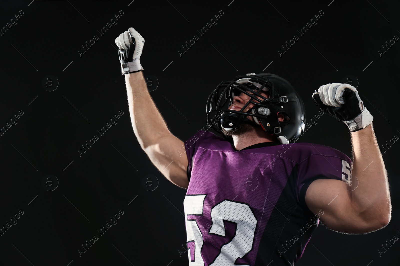 Photo of American football player wearing uniform on dark background