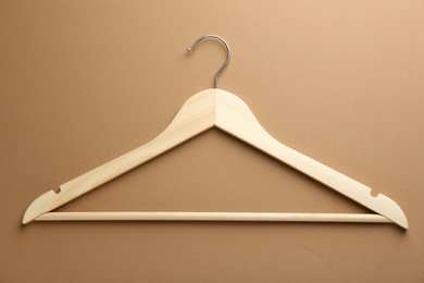 Photo of Empty wooden hanger on brown background, top view