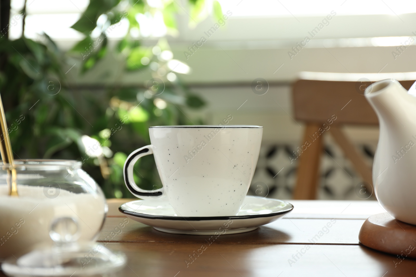Photo of Cup of aromatic tea and sugar on wooden table indoors