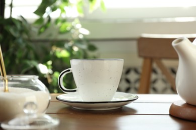 Cup of aromatic tea and sugar on wooden table indoors