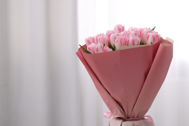 Photo of Beautiful bouquet of fresh pink tulips on blurred background, closeup. Space for text