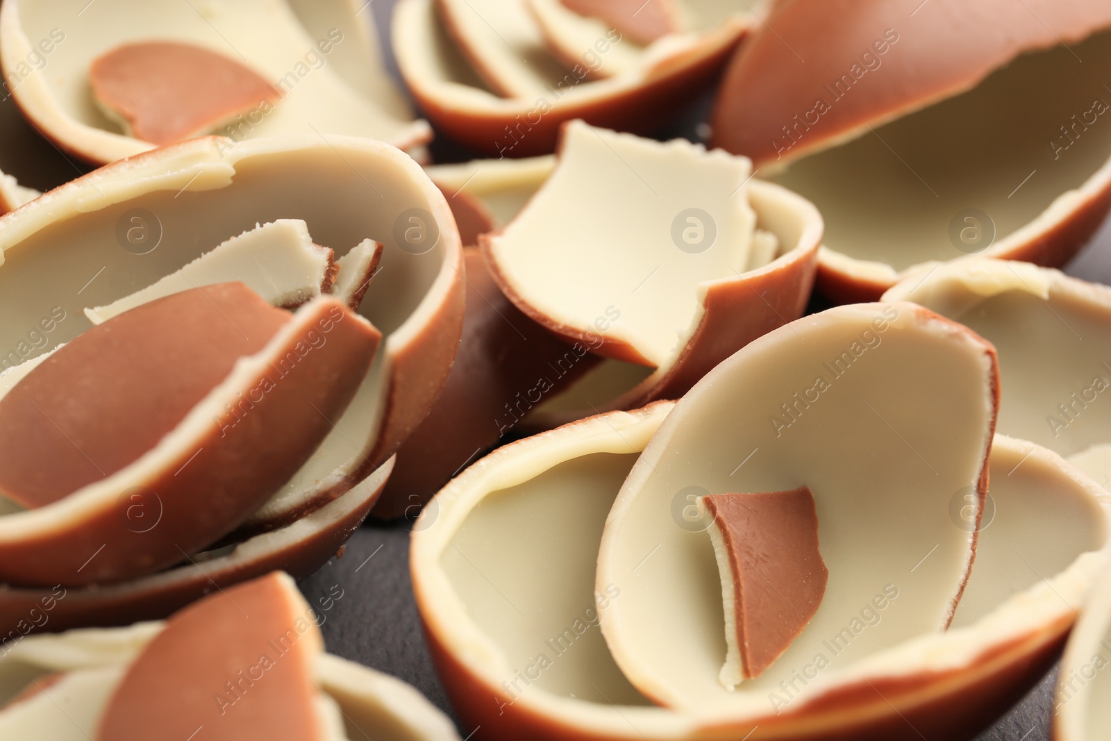 Photo of Sveti Vlas, Bulgaria - July 3, 2023: Broken halves of Kinder Surprise Eggs on grey background, closeup