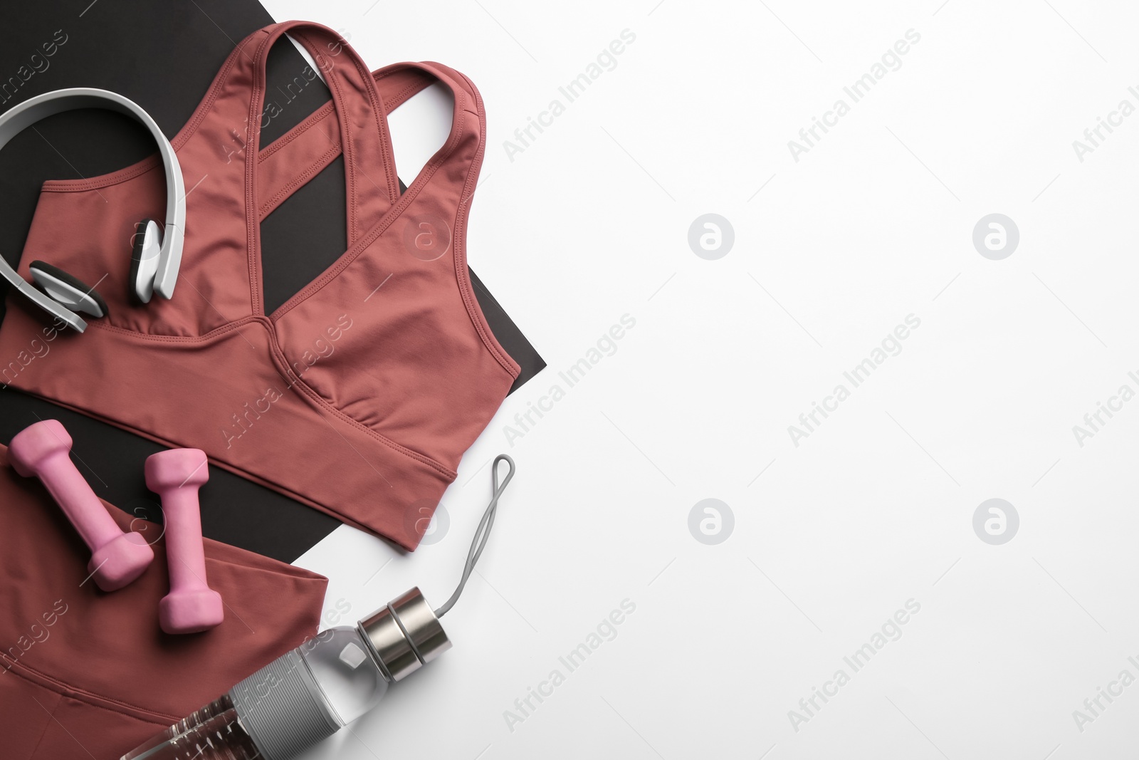 Photo of Flat lay composition with sportswear and equipment on light grey background, space for text. Gym workout