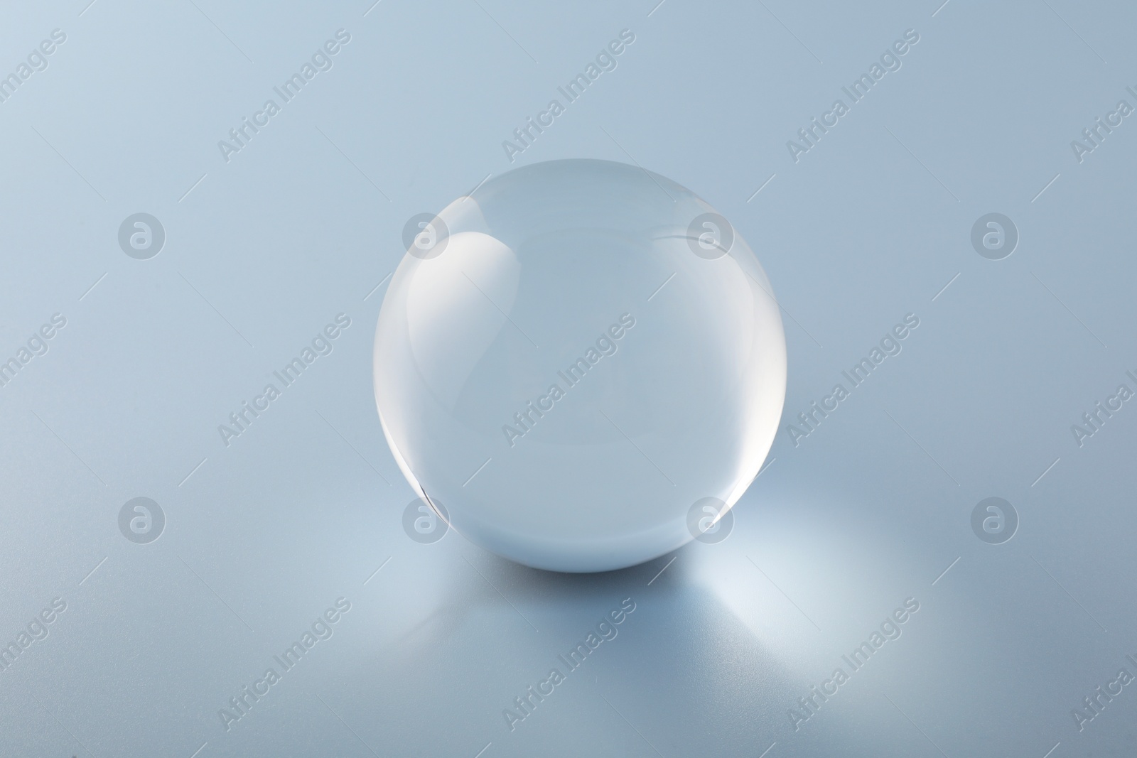 Photo of Transparent glass ball on light grey background