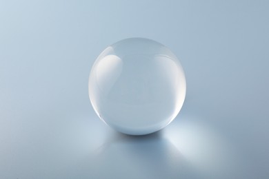 Transparent glass ball on light grey background