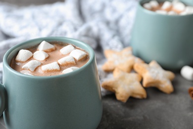 Photo of Composition with delicious cocoa drink and cookies on grey table, closeup