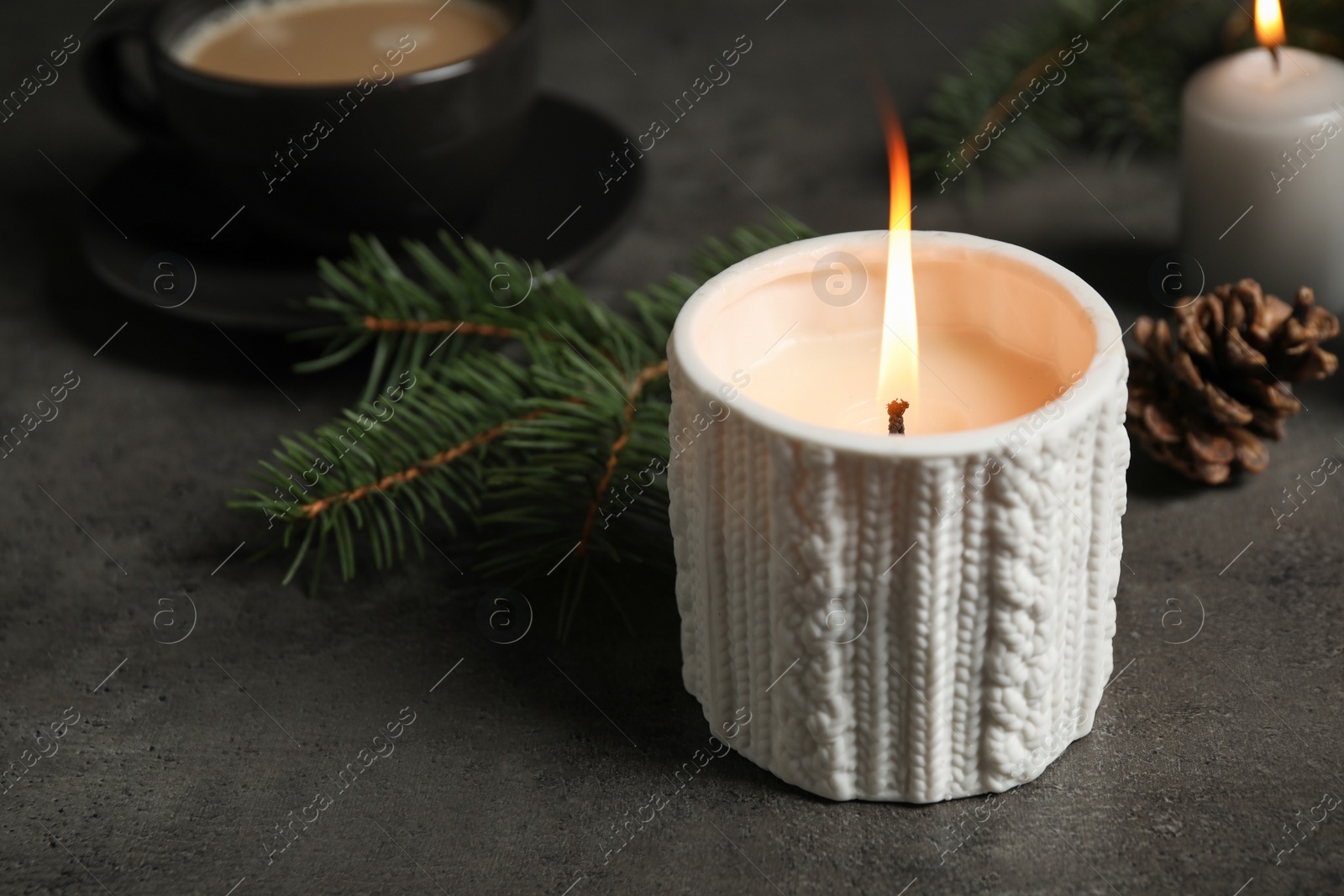 Photo of Candle and Christmas decor on dark grey table, space for text