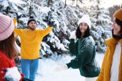 Photo of Happy friends playing snowballs outdoors. Winter vacation