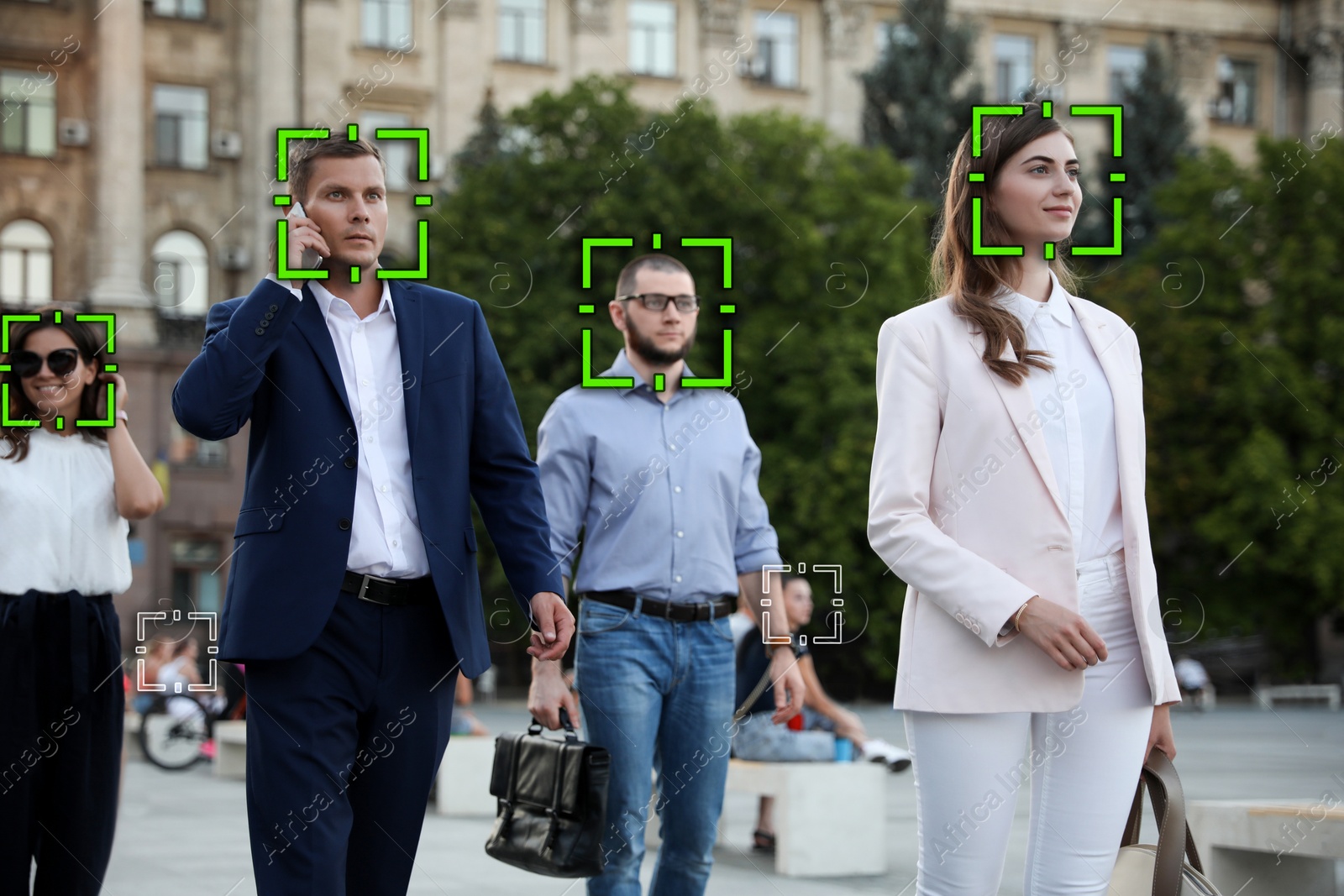 Image of Facial recognition system identifying people on city street 