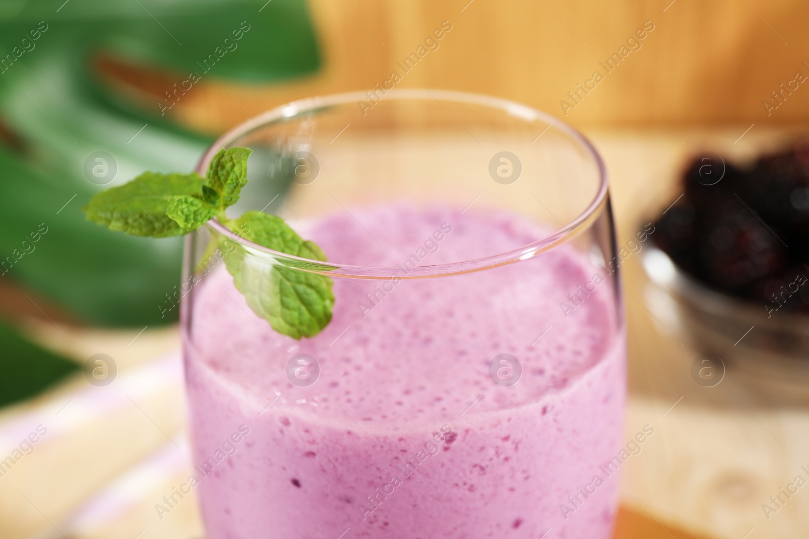 Photo of Delicious blackberry smoothie with mint in glass, closeup