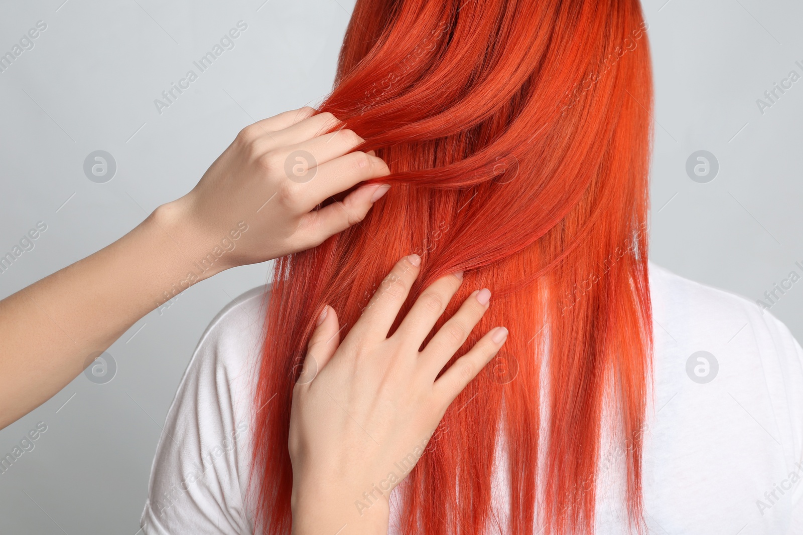 Photo of Woman with bright dyed hair on grey background, back view