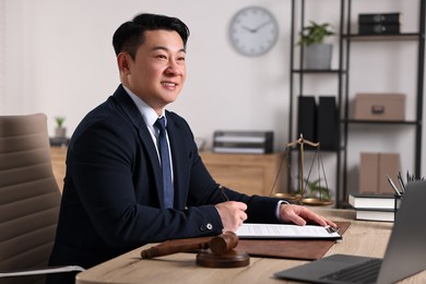 Notary writing notes at wooden table in office