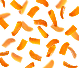 Falling cut orange bell peppers on white background
