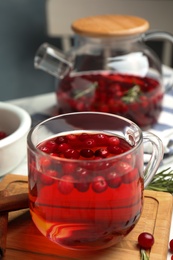 Photo of Tasty hot cranberry tea and fresh ingredients on table