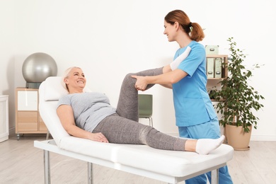 Photo of Physiotherapist working with patient in clinic. Rehabilitation therapy